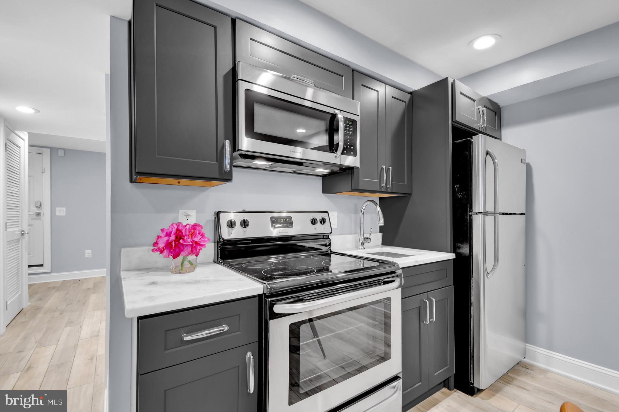 1915 2nd Street Northwest Washington, DC 20001 - Photo 49 of 76 a kitchen with stainless steel appliances granite countertop a stove microwave and refrigerator
