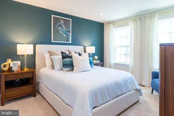 a bedroom with a bed and a lamp on dresser