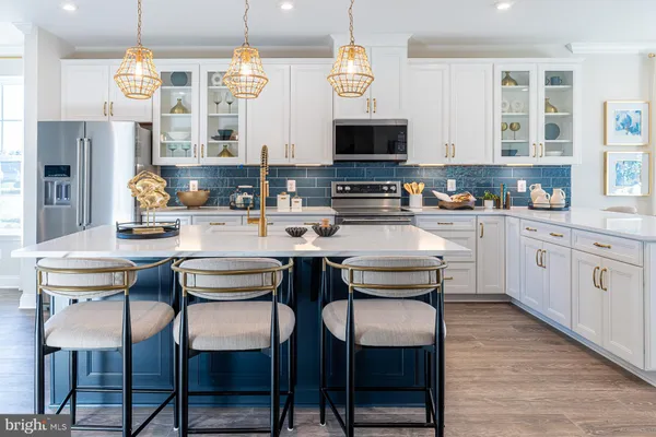 a kitchen with stainless steel appliances kitchen island granite countertop a table chairs sink and cabinets