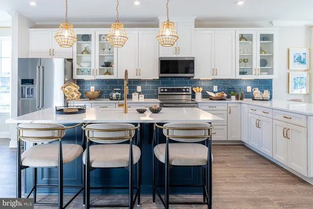 a kitchen with stainless steel appliances kitchen island granite countertop a table chairs sink and cabinets