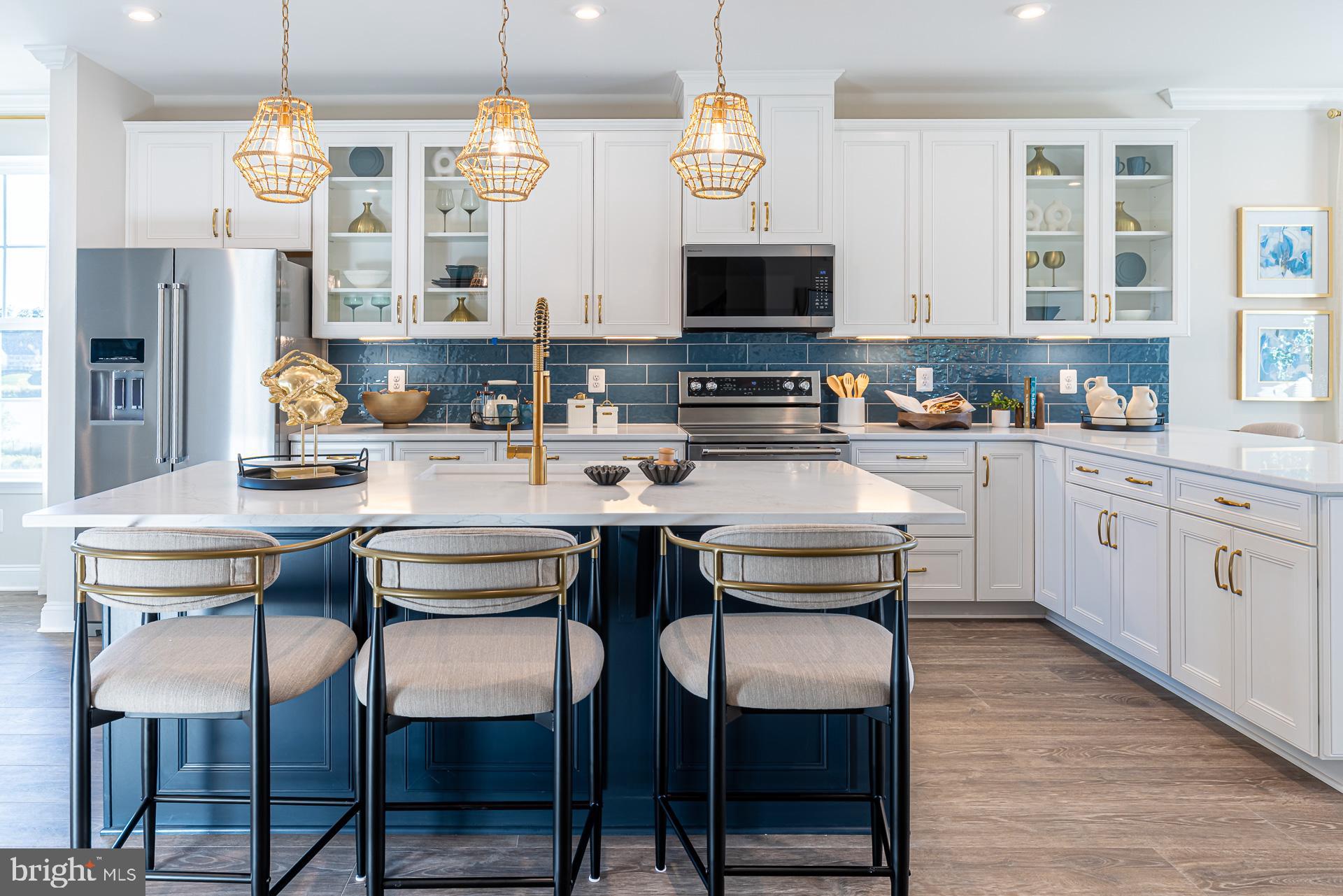 606 Quarry Place Reisterstown, MD 21136 - Photo 3 of 16 a kitchen with stainless steel appliances kitchen island granite countertop a table chairs sink and cabinets