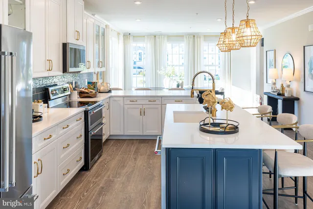 a kitchen with sink a stove and white cabinets with wooden floor