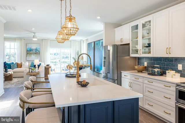 a kitchen with a refrigerator a stove a sink cabinets and living room view