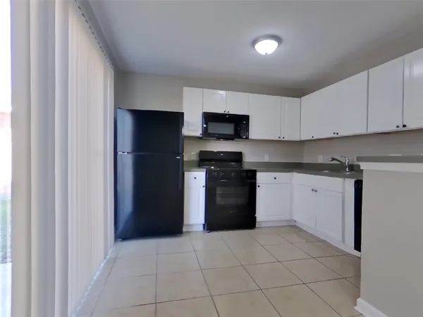 a kitchen with a stove top oven and refrigerator