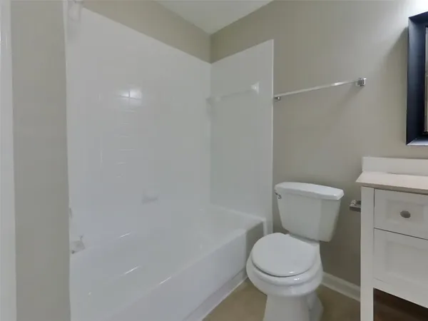 a white toilet sitting next to a bath tub
