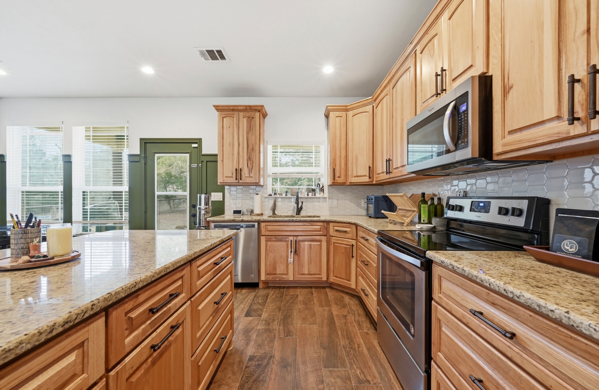 202 Cedar Hills Drive Elgin, TX 78621 - Photo 11 of 37 a kitchen with stainless steel appliances granite countertop a stove a sink and a granite counter tops with wooden floors