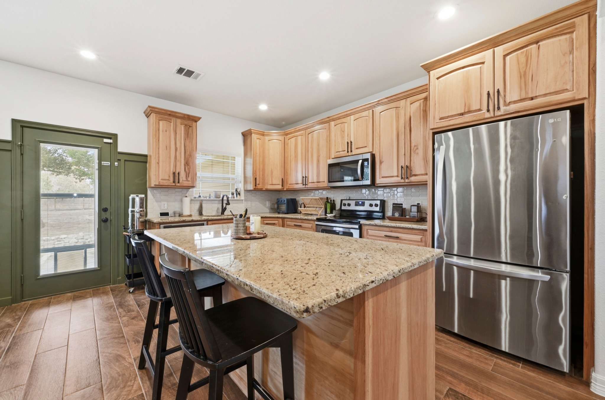 202 Cedar Hills Drive Elgin, TX 78621 - Photo 12 of 37 a kitchen with granite countertop a refrigerator a stove a sink cabinets and a dining table
