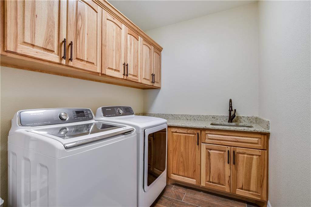 202 Cedar Hills Drive Elgin, TX 78621 - Photo 29 of 37 a utility room with stainless steel appliances granite countertop a sink and a stove