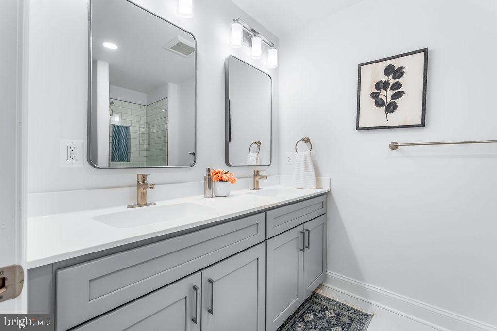 107 South Fulton Avenue Baltimore, MD 21223 - Photo 14 of 36 a bathroom with a double vanity sink and a mirror