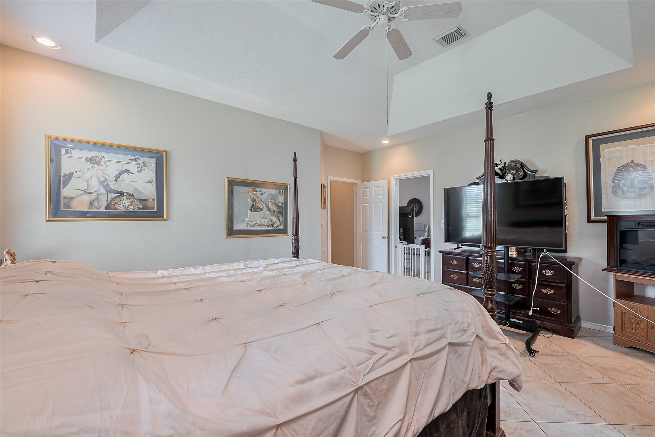 2499 Southline Road Conroe, TX 77384 - Photo 34 of 49 Spacious primary bedroom featuring tray ceilings, ceiling fan, and plenty of room for large furnishings.