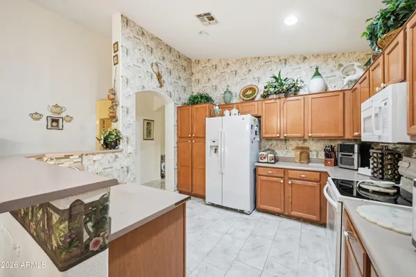 a kitchen with a refrigerator a stove a sink dishwasher and wooden cabinets with wooden floor