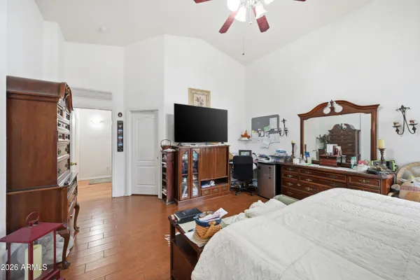 a bedroom with a bed and a flat tv screen on the dresser