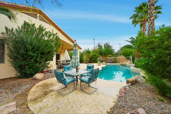 a view of backyard with swimming pool and outdoor seating