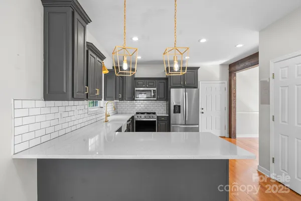a kitchen with stainless steel appliances granite countertop a sink stove and refrigerator