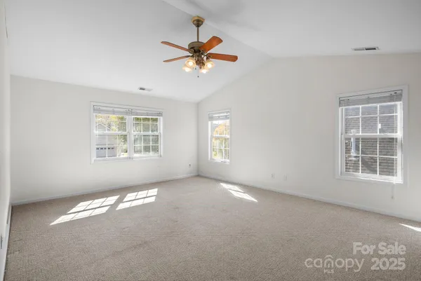 an empty room with fan and windows