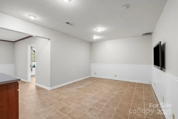 an empty room with a cabinet and a flat screen tv