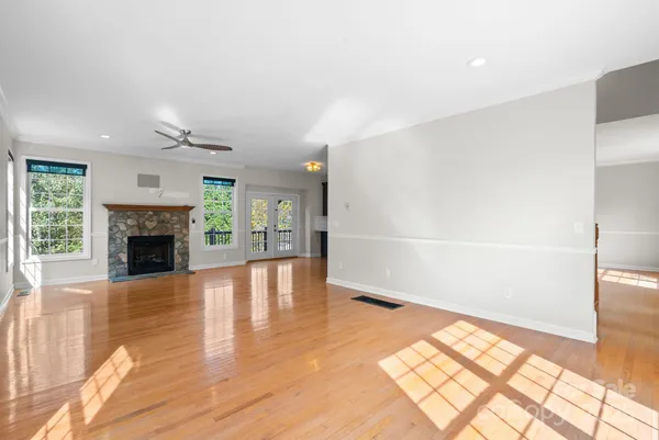 a view of a livingroom with a fireplace wooden floor and windows