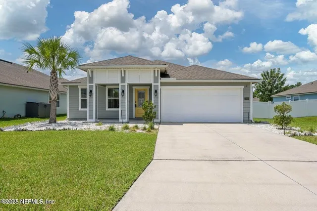 a front view of a house with a garden and yard
