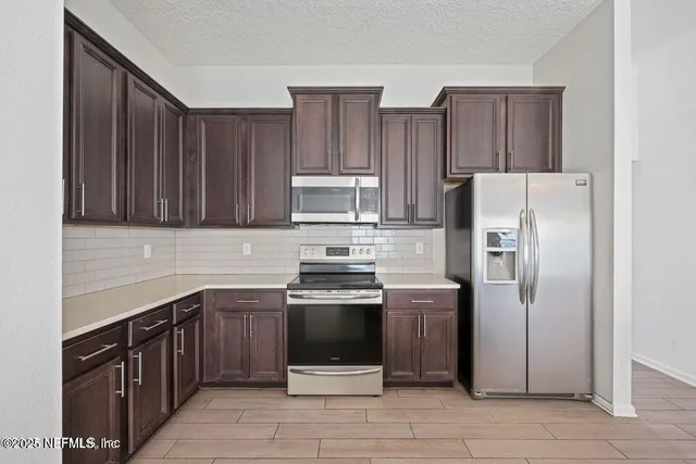 a kitchen with stainless steel appliances granite countertop a refrigerator stove a sink and dishwasher