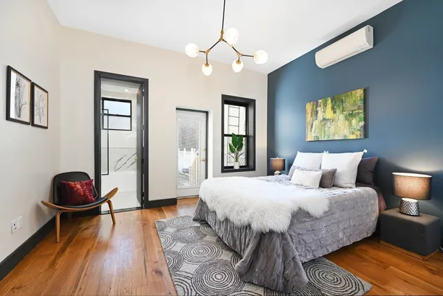 a bedroom with a bed and wooden floor