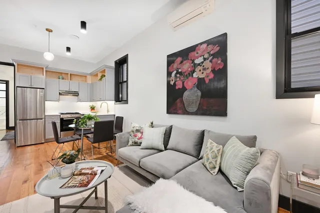 a living room with furniture kitchen view and a window