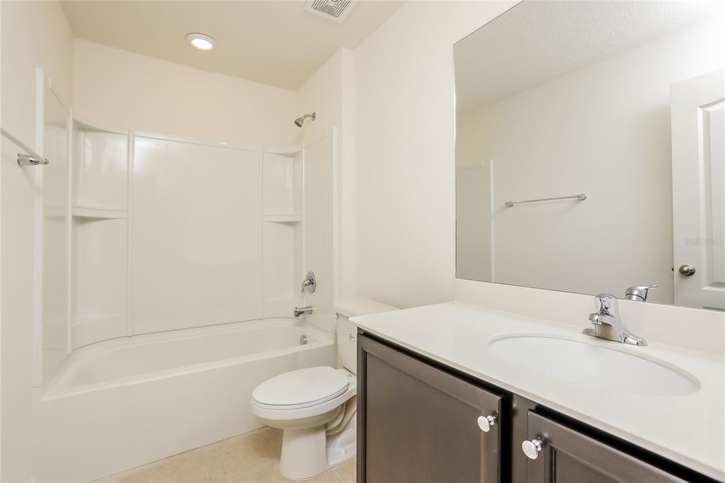 1668 Gopher Tree Street Mascotte, FL 34753 - Photo 13 of 16 a bathroom with a sink a toilet and shower