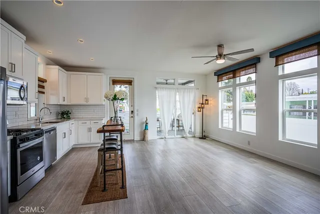 a large kitchen with cabinets wooden floor and stainless steel appliances