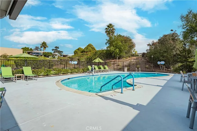 a view of a swimming pool with a patio and a yard