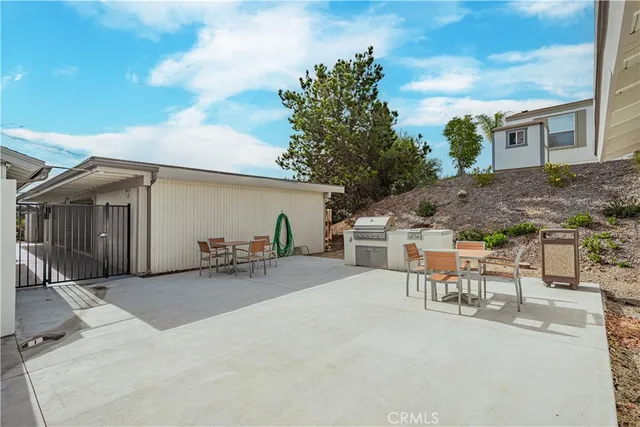 a kitchen with stainless steel appliances granite countertop a kitchen island a stove a refrigerator a oven a sink with a dining table and chairs