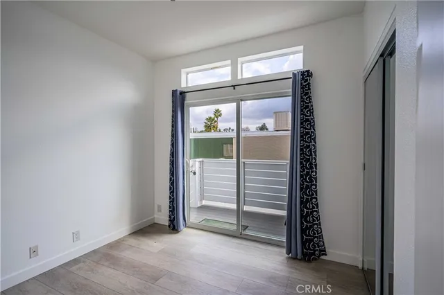a view of a hallway with bathroom and wooden floor
