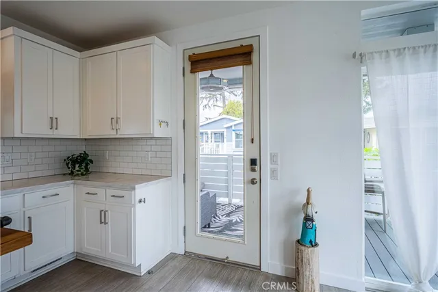 a kitchen with white cabinets and wooden floor