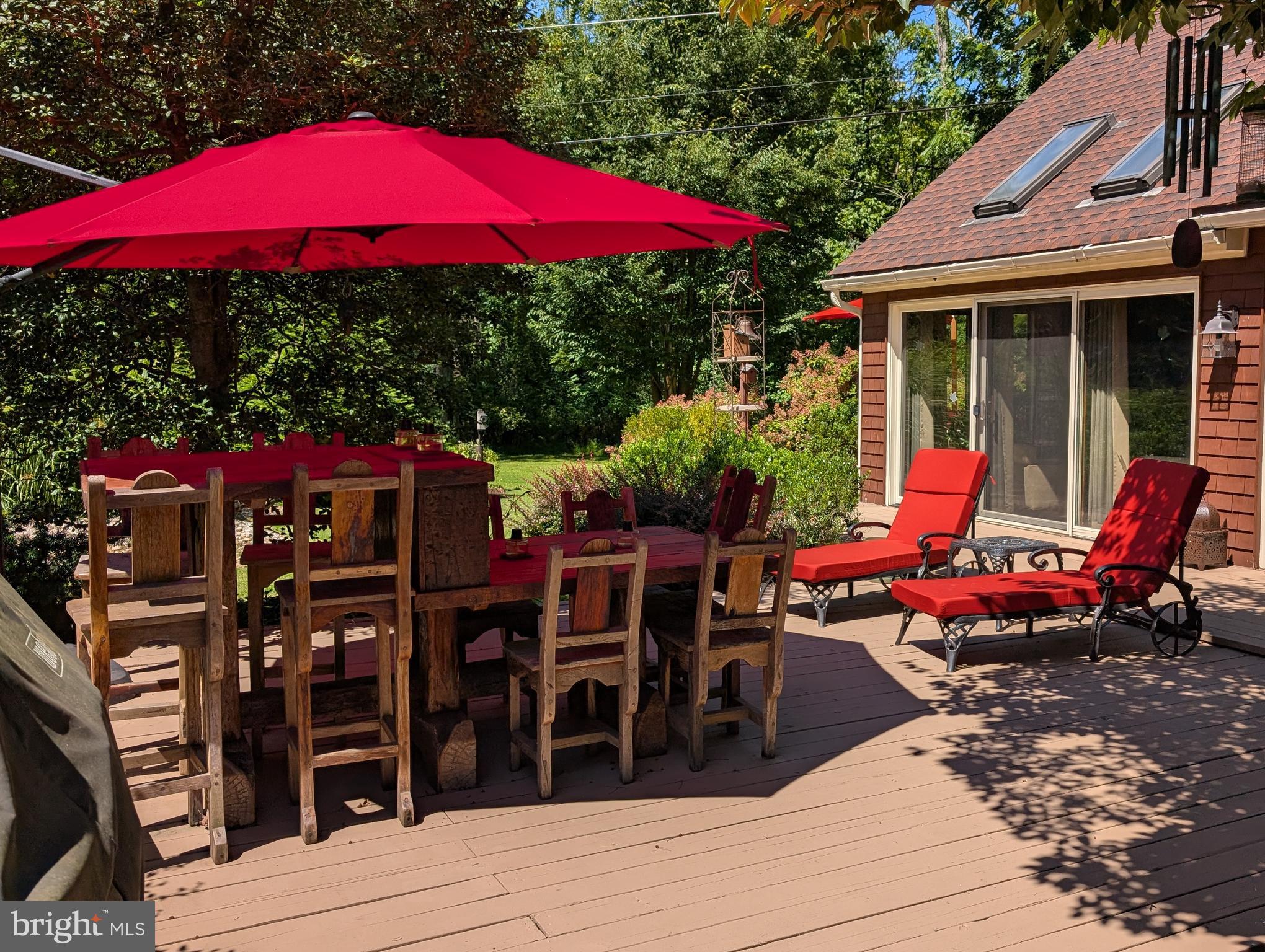 2125 Old Woods Road Green Lane, PA 18054 - Photo 43 of 53 a view of a patio with table and chairs under an umbrella with wooden floor