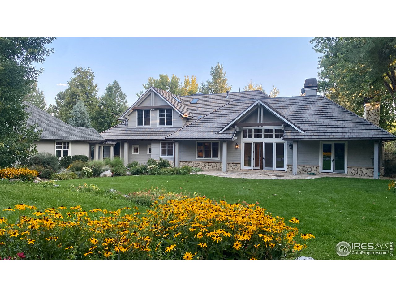 a view of a big house with a big yard and potted plants