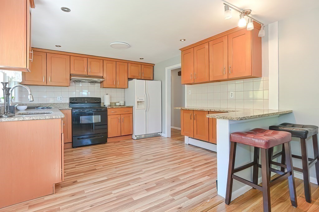 24 Cherry Road Framingham, MA 01701 - Photo 11 of 30 a kitchen with stainless steel appliances wooden floors and wooden cabinets