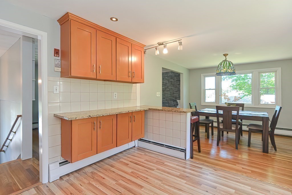 24 Cherry Road Framingham, MA 01701 - Photo 12 of 30 a kitchen with stainless steel appliances granite countertop wooden floor a dining table and chairs