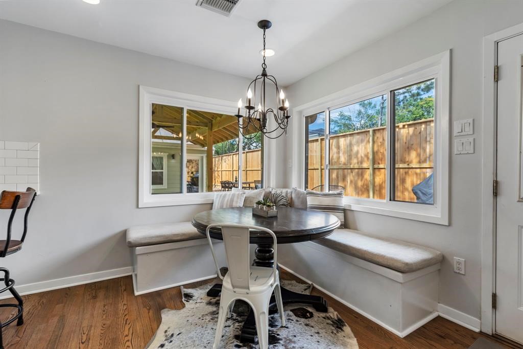 982 West 42nd Street Houston, TX 77018 - Photo 6 of 20 a dining room with wooden floor a chandelier a wooden table and chairs