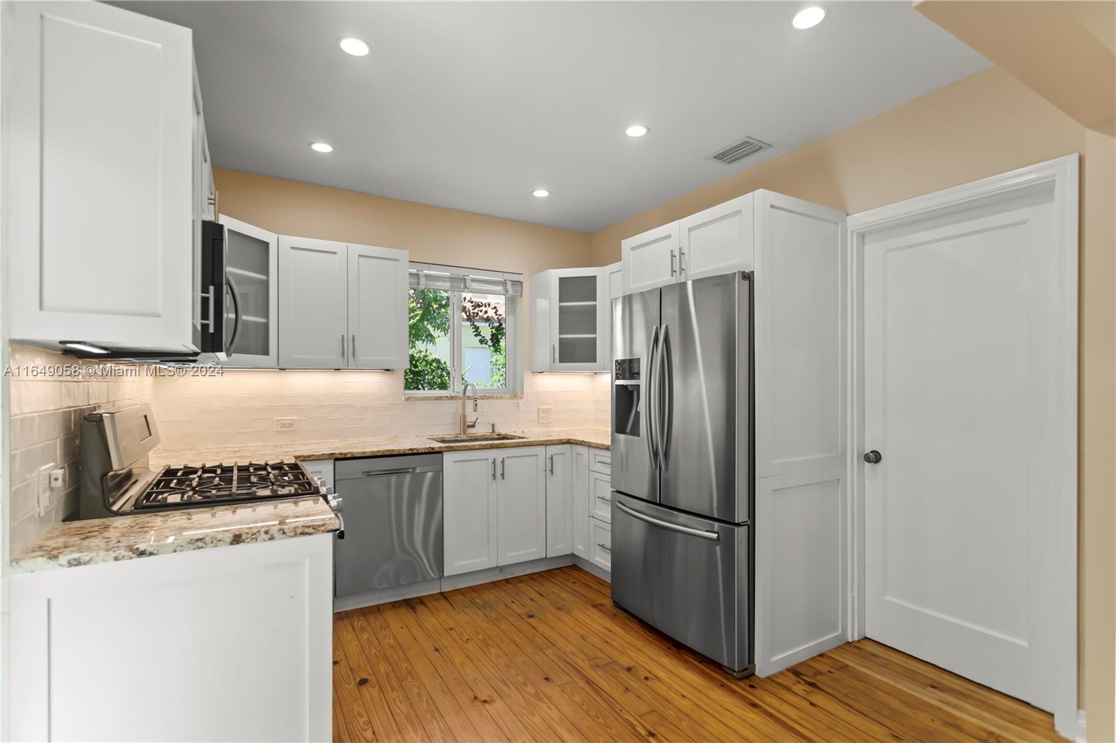 610 Southwest 25th Road Miami, FL 33129 - Photo 13 of 46 a kitchen with a sink a refrigerator and wooden cabinets