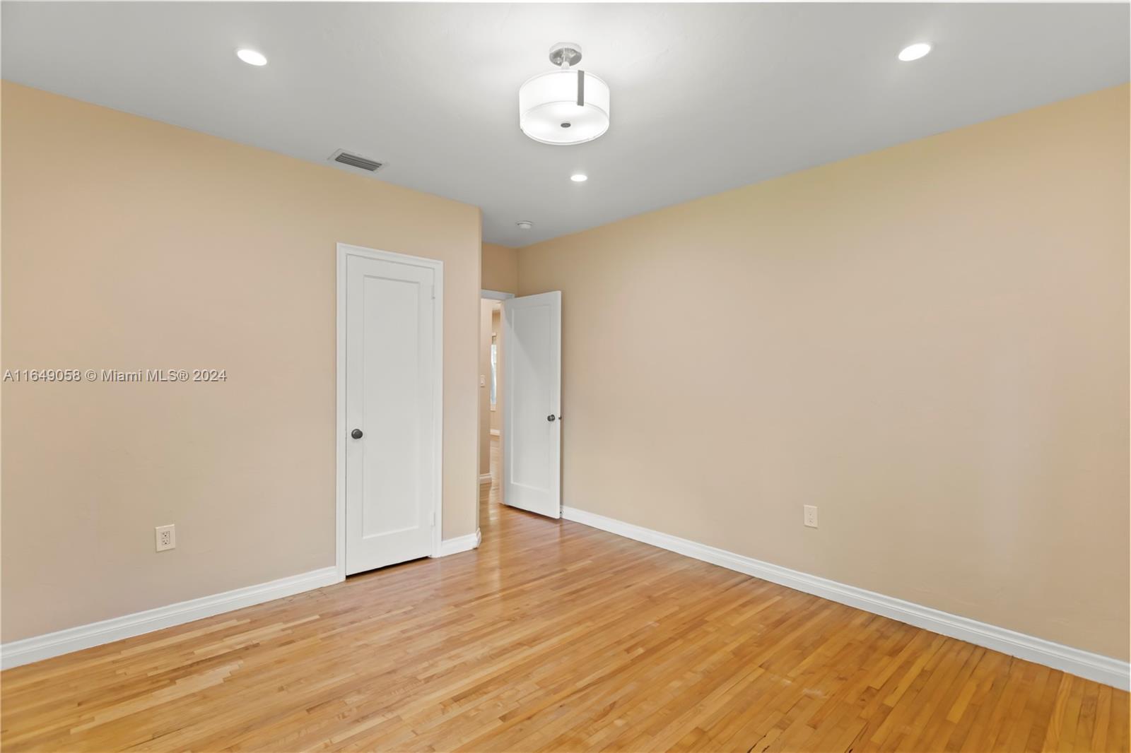 610 Southwest 25th Road Miami, FL 33129 - Photo 30 of 46 a view of an empty room with wooden floor and ceiling fan