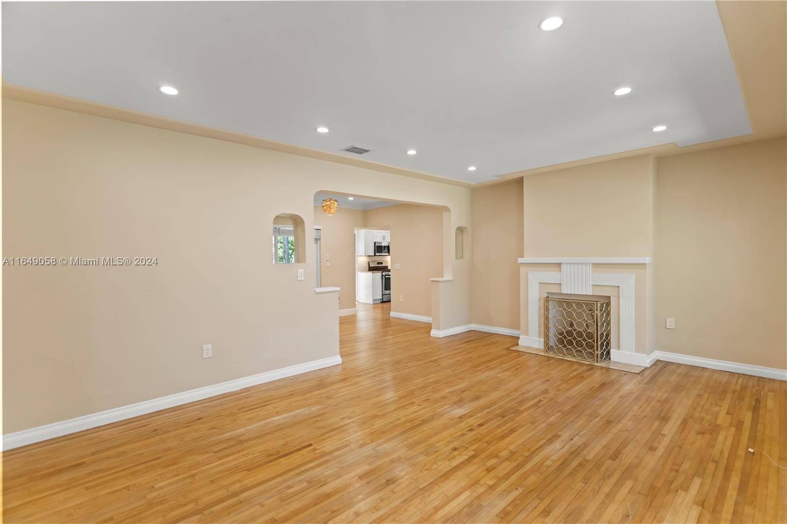 610 Southwest 25th Road Miami, FL 33129 - Photo 3 of 46 an empty room with wooden floor and fireplace
