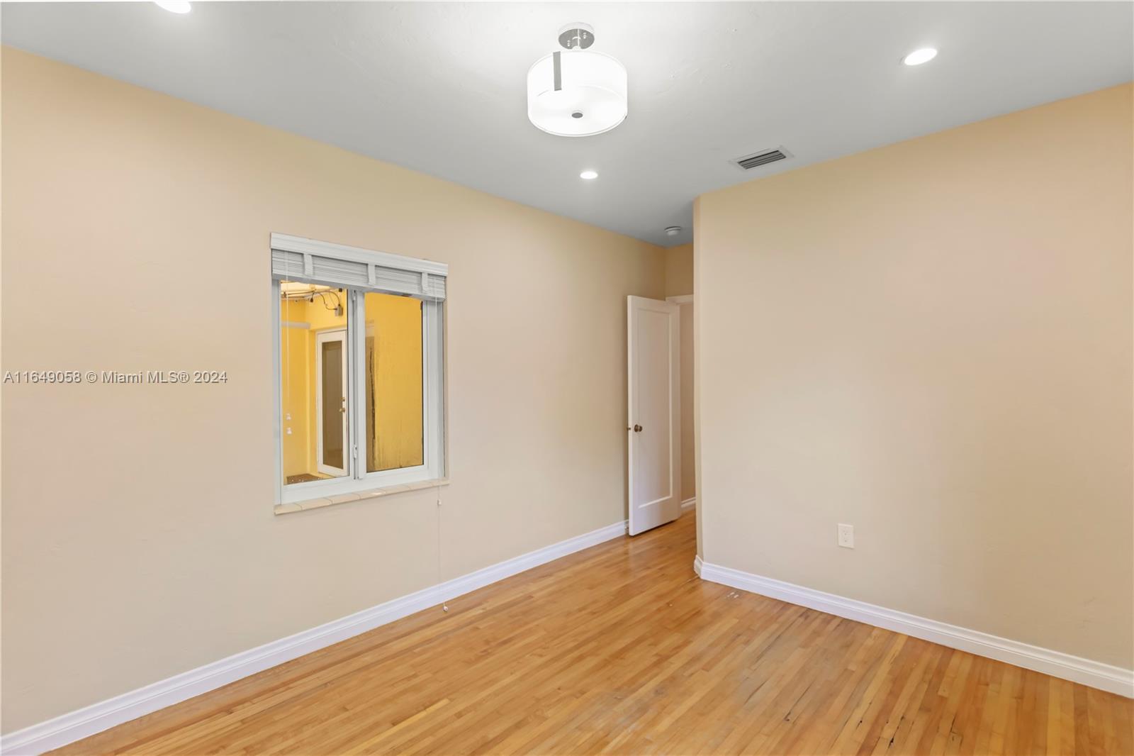 610 Southwest 25th Road Miami, FL 33129 - Photo 39 of 46 a view of an empty room with wooden floor and a window