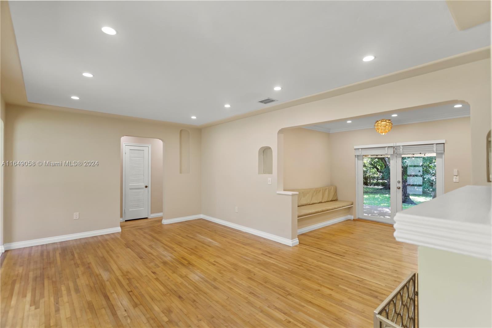 610 Southwest 25th Road Miami, FL 33129 - Photo 6 of 46 a view of an empty room with wooden floor and a window