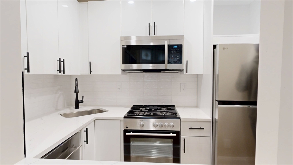 41 Edgerly Road, Unit 1 Boston, MA 02115 - Photo 8 of 12 a kitchen with a stove and a refrigerator