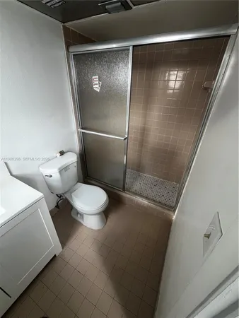 a white toilet sitting next to a shower