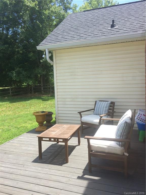 1037 Ridgefield Circle Indian Trail, NC 28079 - Photo 16 of 19 a view of a patio with table and chairs with wooden floor and fence