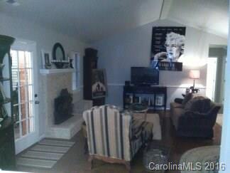 1037 Ridgefield Circle Indian Trail, NC 28079 - Photo 17 of 19 a living room with furniture a fireplace and a chandelier
