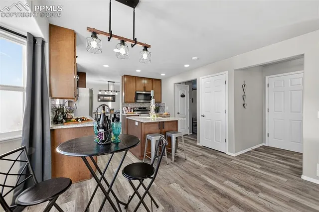 a kitchen with a table chairs refrigerator and cabinets