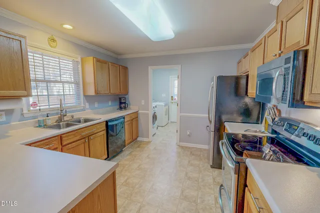 a kitchen with stainless steel appliances granite countertop a refrigerator stove and sink