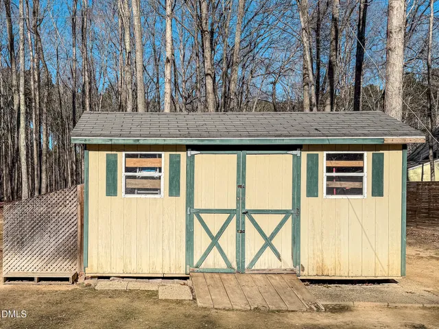 a view of a house with a wooden fence