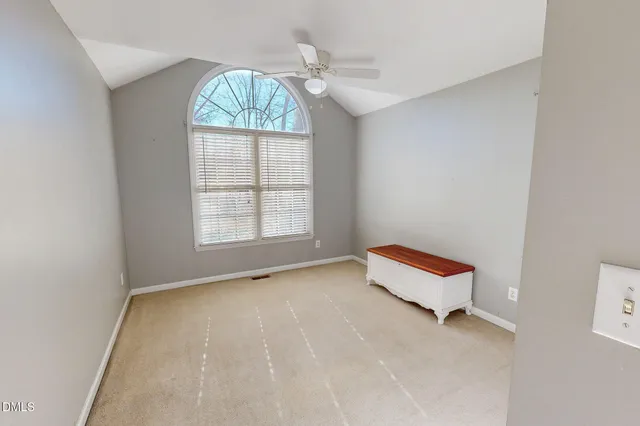 an empty room with windows and ceiling fan