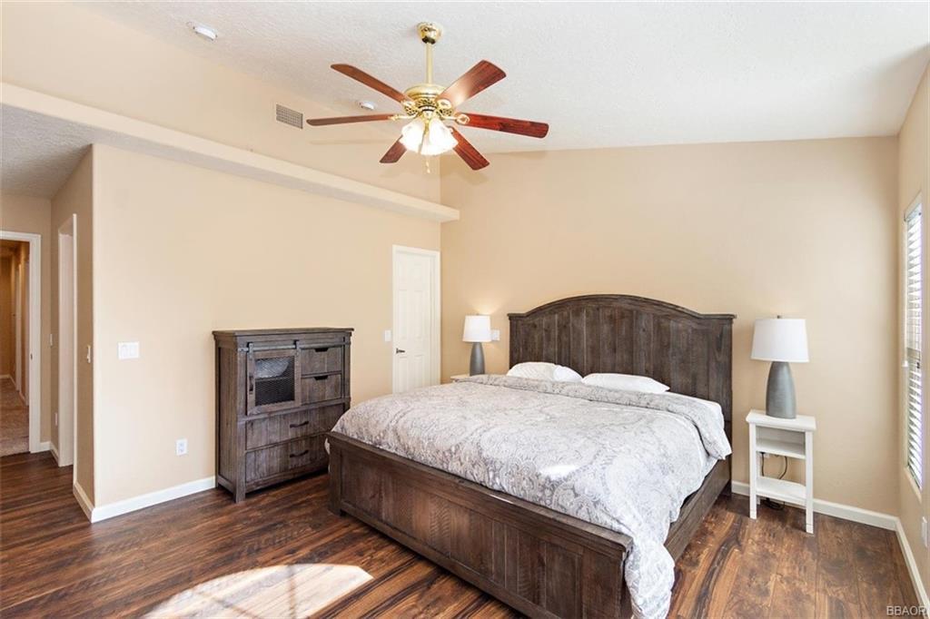 613 Riverside Avenue Sugarloaf, CA 92386 - Photo 12 of 27 a bedroom with a bed and a chandelier